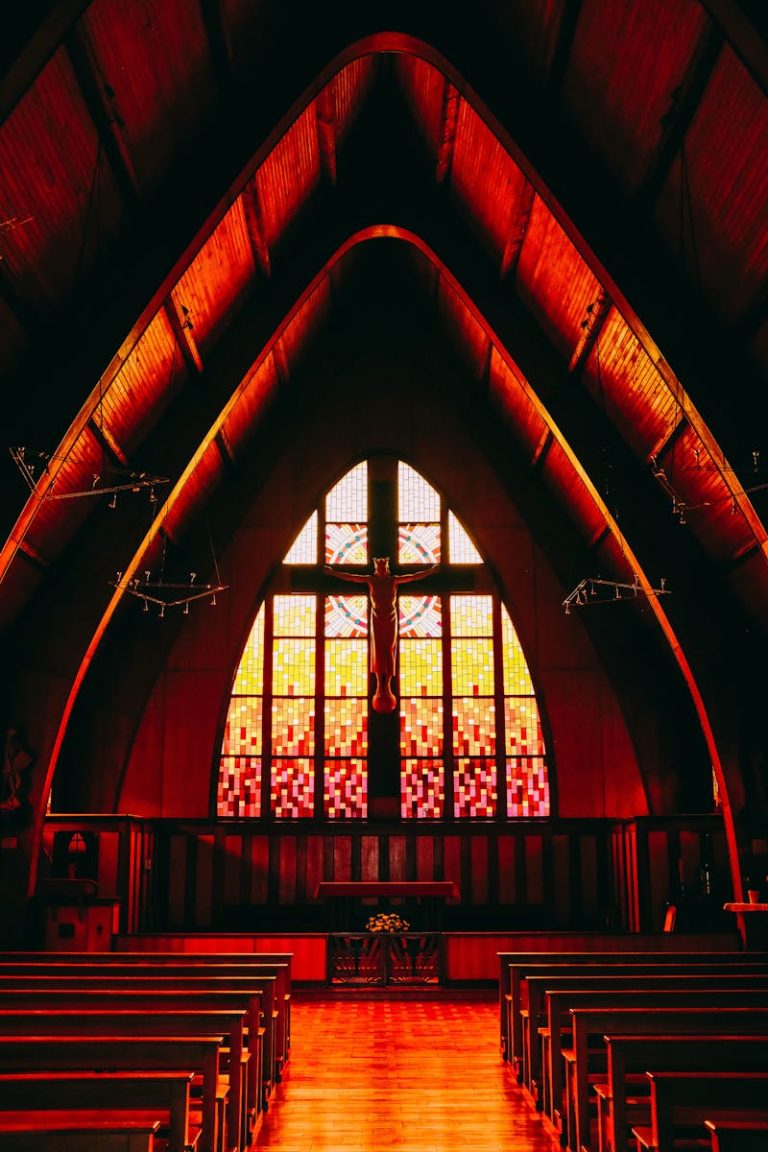 A stunning church interior with vibrant stained glass windows and wooden pews.